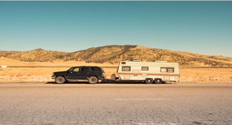 A picture of a car and trailer broken down on the side of the road waiting for a tow truck provided by Red Shield Administration.